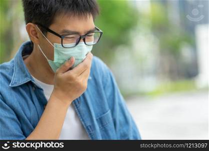 HandsomeMan wearing face mask protect filter against air pollution (PM2.5) or wear N95 mask. protect pollution, anti smog and viruses, Air pollution caused health problem. Global warming concept.