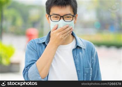HandsomeMan wearing face mask protect filter against air pollution (PM2.5) or wear N95 mask. protect pollution, anti smog and Covid 19 viruses, Air pollution caused health problem. Global warming.