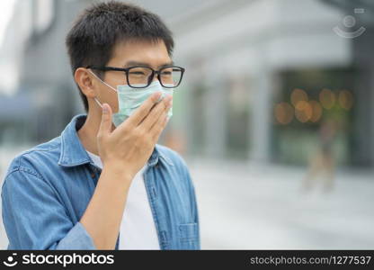 HandsomeMan wearing face mask protect filter against air pollution (PM2.5) or wear N95 mask. protect pollution, anti smog and viruses, Air pollution caused health problem. Global warming concept.