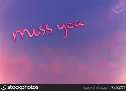 Handwritten phrase miss you on the pink and purple blur background, enjoying relationships, affection and first love concept, happy Valentines day holiday. Miss you after each date