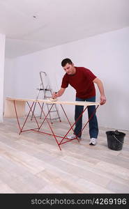 Handyman applying glue on wallpaper