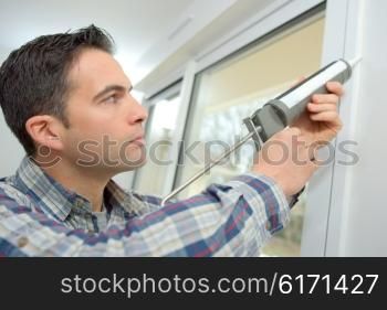 Handyman caulking a window