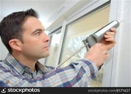 Handyman caulking a window