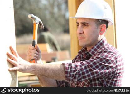 Handyman hitting a nail with a hammer