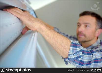 Handyman installing a window shutter