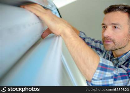 Handyman installing a window shutter