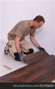 handyman laying floorboards