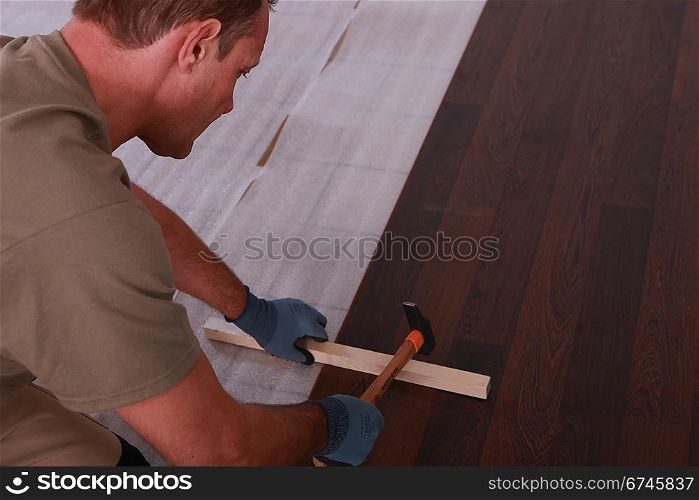 handyman laying floorboards