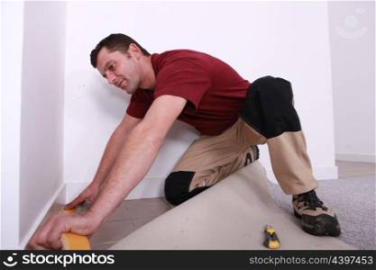 handyman laying wall-to-wall carpet
