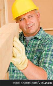 Handyman mature carpenter measures wooden beam for new home improvement