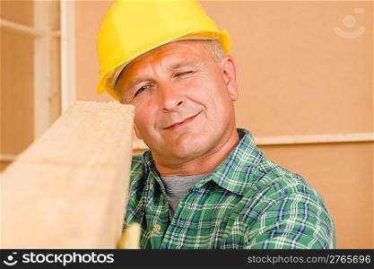 Handyman mature carpenter measures wooden beam for new home improvement