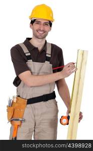 Handyman measuring a wooden plank