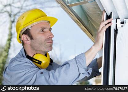 handyman repairs window with screwdriver