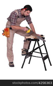 Handyman sawing a plank of wood