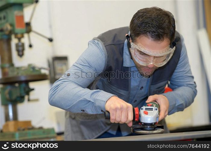 handyman using electric sander with safety glasses