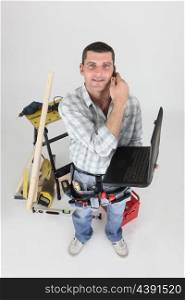 Handyman with a phone and laptop