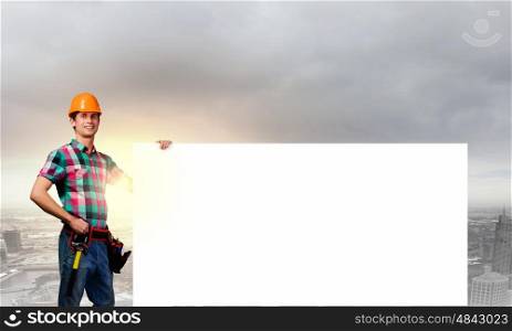 Handyman with banner. Young repairman with white blank banner. Place for text