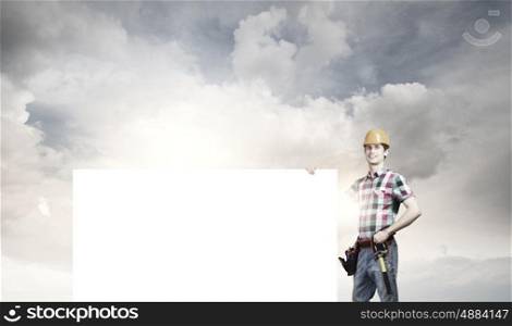 Handyman with banner. Young repairman with white blank banner. Place for text