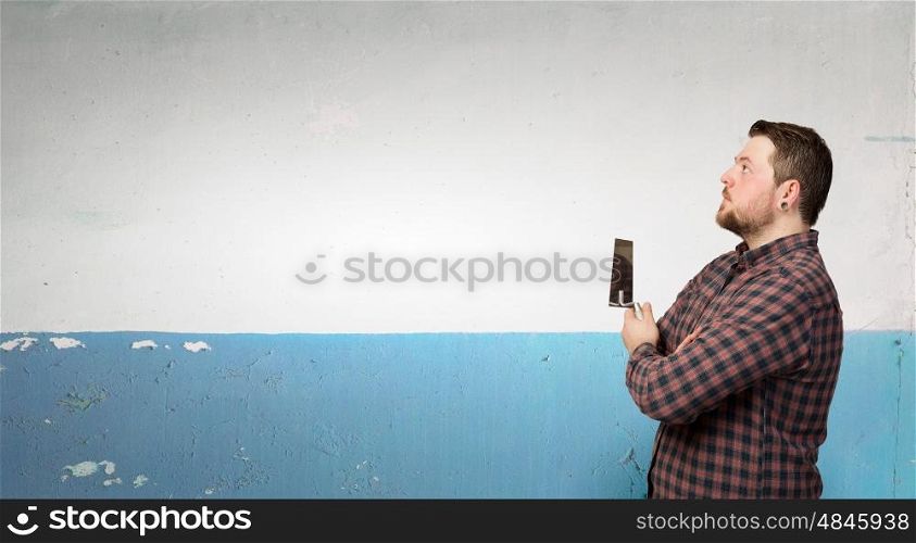 Handyman with tool in interior. Good looking caucasian manual worker with spatula tool inside house