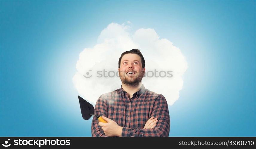 Handyman with tool in interior. Good looking caucasian manual worker with spatula tool inside house