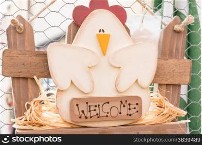Hanged green home wooden decoration chicken shaped: welcome letters. Golden hooks underneath.