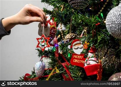 Hanging Christmas decorations and ornaments in the Christmas tree
