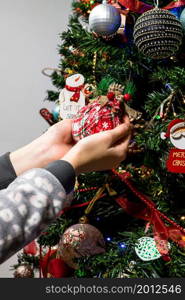 Hanging Christmas decorations and ornaments in the Christmas tree