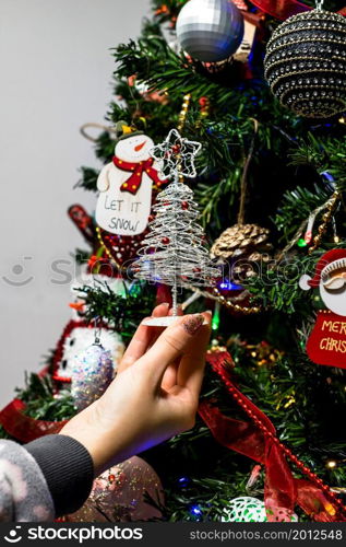 Hanging Christmas decorations and ornaments in the Christmas tree