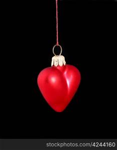 Hanging Christmas red heart isolated on black background