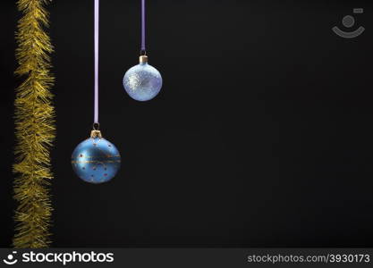 Hanging colorful christmas balls on black background. Hanging two colorful christmas balls on black background