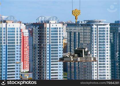 Hanging concrete bloks. Modern apartment buildings on the background