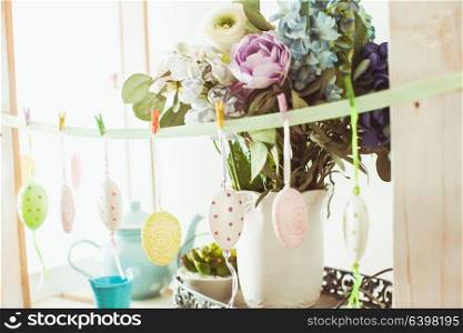 Hanging eggs on the ribbon - Easter decortaions on the shelf indoor. Easter decortaions interior