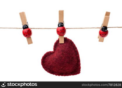 Hanging heart. Red heart hanging on a clothesline, three pins, white background