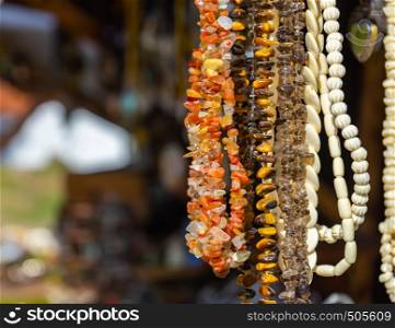 Hanging jewellery necklaces with coloured semi-precious stones, coloured stones and small white ivory pieces and amber.