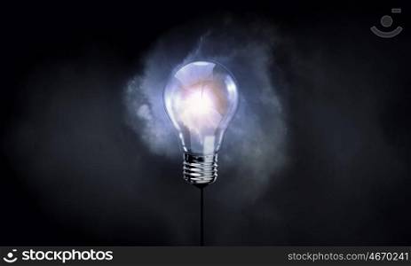 Hanging light bulb. Glowing inverted light bulb on dark background