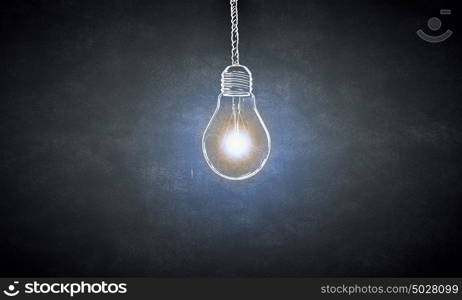 Hanging light bulb. Glowing light bulb on dark background hanging from above