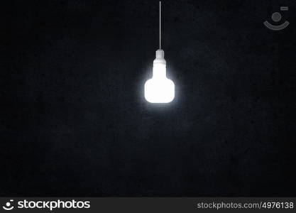 Hanging light bulb. Illuminating hanging light bulb on dark background