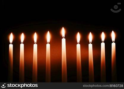 Hanukkah candles. Traditional candelabrum with burning candles on black background. Celebrating a religious Jewish holiday.. Hanukkah candles. Traditional candelabrum with burning candles on black background. Celebrating religious Jewish holiday.