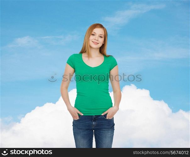 happiness, advertisement and people concept - smiling teenage girl in casual clothes over blue sky with white cloud background
