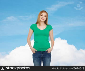 happiness, advertisement and people concept - smiling teenage girl in casual clothes over blue sky with white cloud background