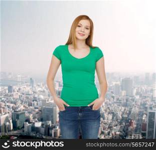 happiness, advertisement and people concept - smiling teenage girl in casual clothes over city background