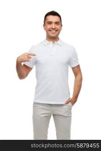 happiness, advertisement, fashion, gesture and people concept - smiling man in t-shirt pointing finger on himself