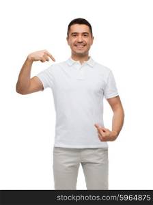 happiness, advertisement, fashion, gesture and people concept - smiling man in t-shirt pointing fingers on himself