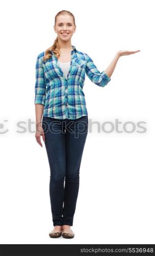 happiness, advertising and people concept - smiling young woman holding something on palm of her hand