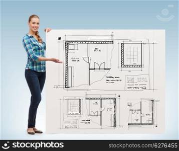 happiness, advertising and people concept - smiling young woman pointing hand board with blueprint