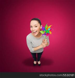 happiness and ecology concept - smiling asian woman with windmill