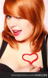 Happiness and love concept. Happy redhair woman smiling girl holding valentine red heart on chest. Valentines day.