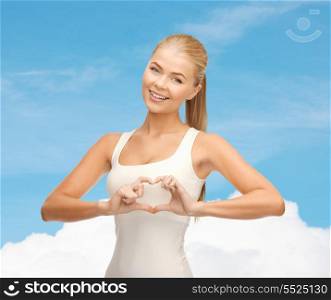 happiness and medicine concept - smiling woman showing heart shape gesture