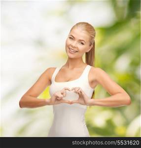 happiness and medicine concept - smiling woman showing heart shape gesture