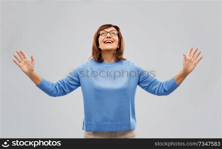 happiness and old people concept - happy senior woman looking up thanks god over grey background. happy senior woman looking up thanks god